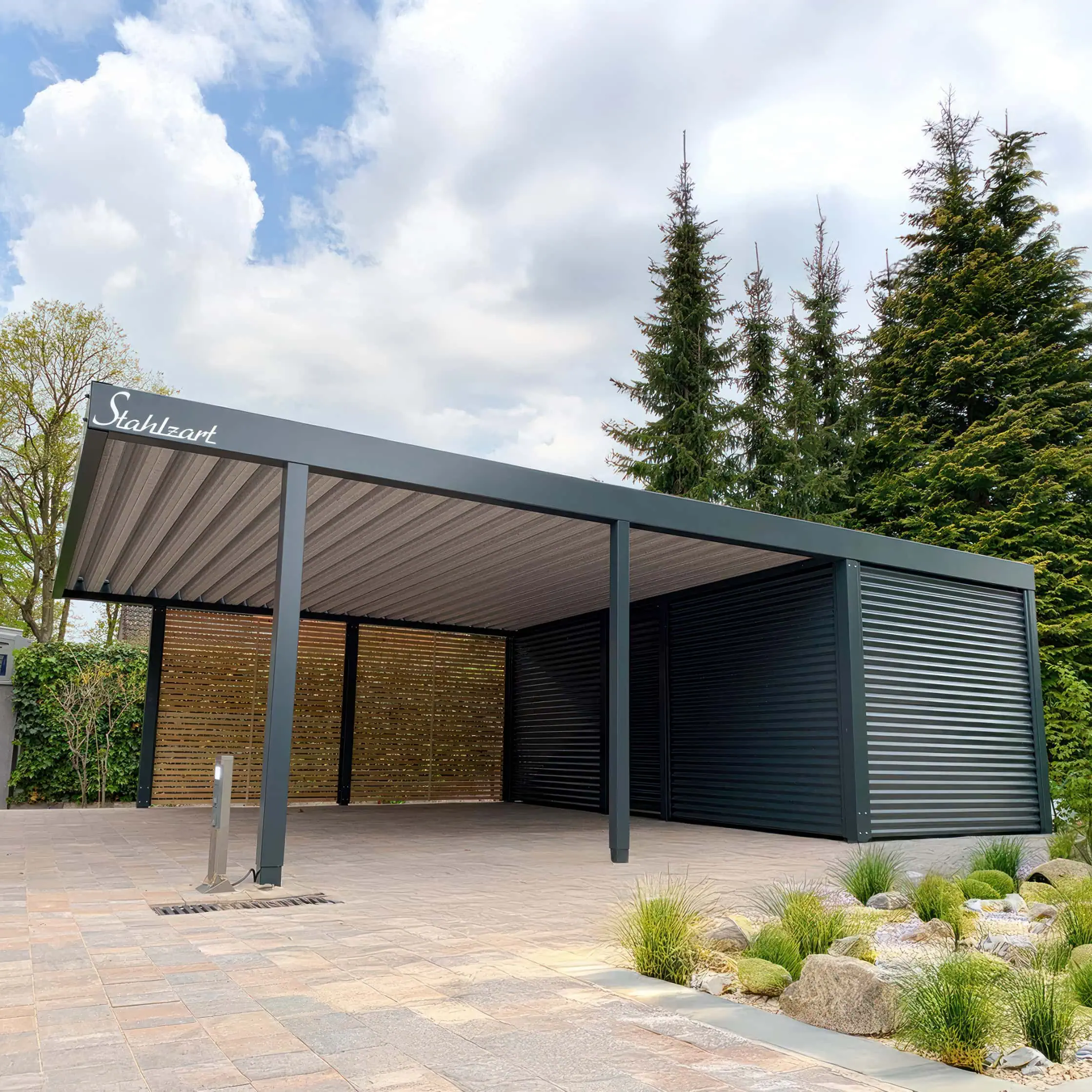 Moderner Stahlzart Doppelcarport in Anthrazit mit einem großen Geräteraum an der Rückseite aus Blechwelle und einer offenen rechten Seitenwand aus Holz als Design-Akzent.