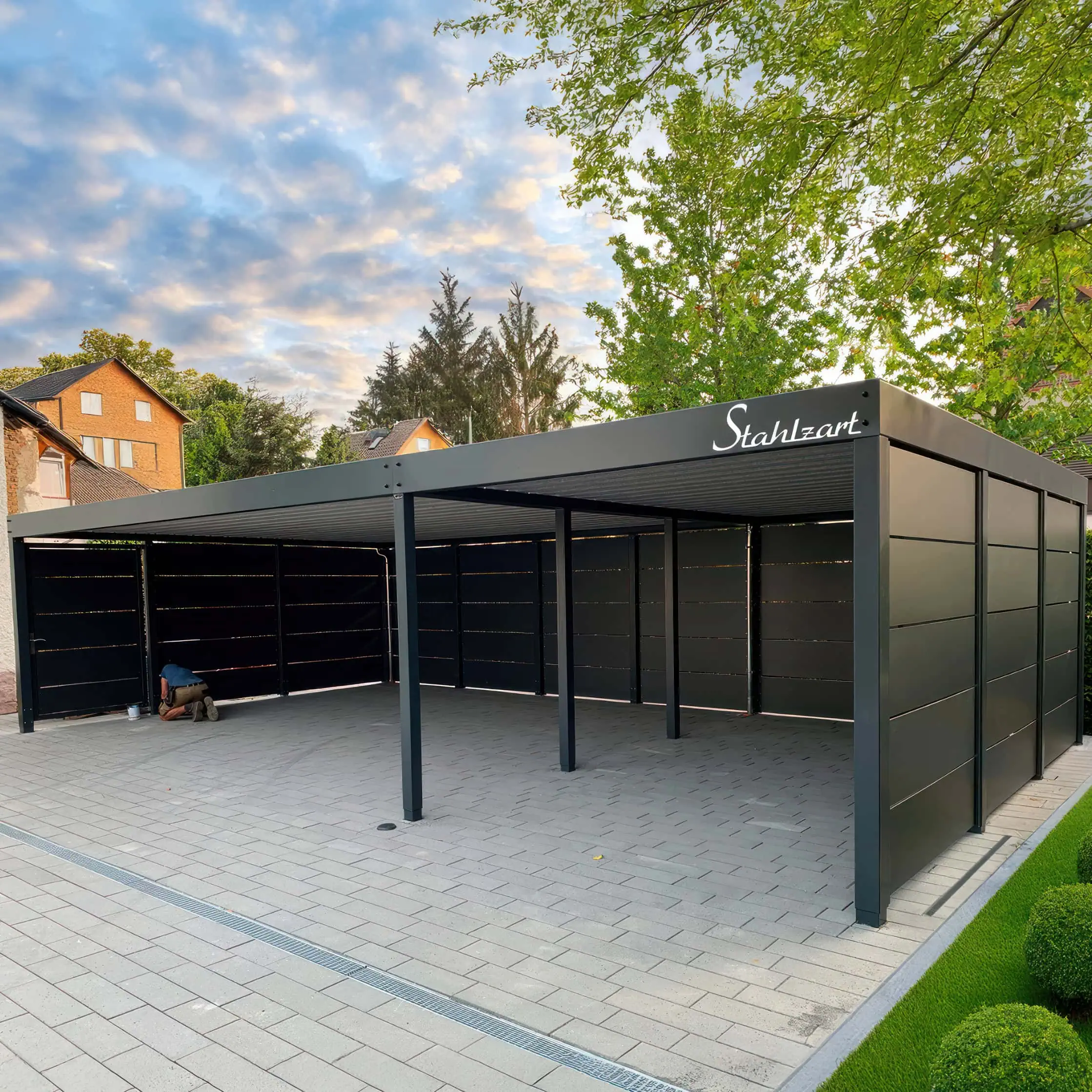 Moderner 3er-Reihencarport von Stahlzart aus pulverbeschichtetem Stahl in Anthrazit, an drei Seiten mit blickdichten Wänden geschlossen und mit einem Flachdach ausgestattet.